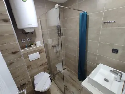 a bathroom with a shower with a toilet and a sink at Apartman N98 Milmari Kopaonik in Kopaonik