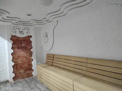 a room with a bench and a brick wall at Apartman N99 Milmari Kopaonik in Kopaonik