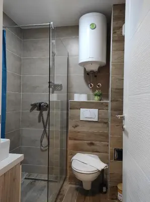 a bathroom with a toilet and a glass shower at Apartman N99 Milmari Kopaonik in Kopaonik