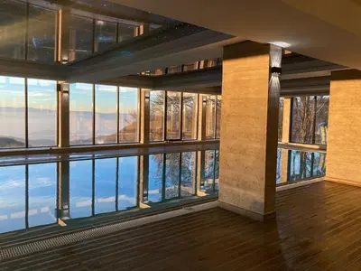 a room with large windows and a view of the water at Apartman N99 Milmari Kopaonik in Kopaonik