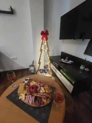 a plate of food on a table with a christmas tree at Aparmani Sorak Kopaonik, Studio Apartman A5 in Kopaonik