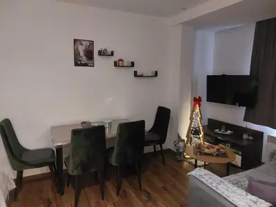 a living room with a dining room table and chairs at Aparmani Sorak Kopaonik, Studio Apartman A5 in Kopaonik