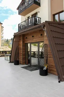 a house with a balcony and a stair case at Aparmani Sorak Kopaonik, Studio Apartman A5 in Kopaonik