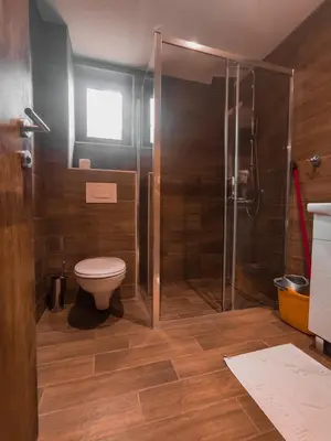 a bathroom with a toilet and a glass shower at Aparmani Sorak Kopaonik, Studio Apartman A5 in Kopaonik