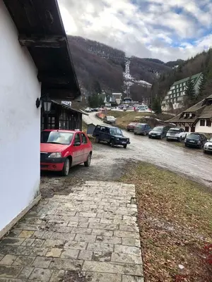 a car parked in a parking lot next to a building at BELE STAZE-Brzece,Kopaonik in Brzeće