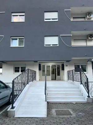 a building with a ramp leading to a building with a car at Apartman Natura in Vrnjačka Banja