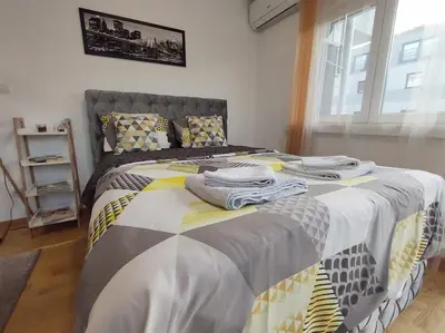 a bedroom with a bed with towels on it at Apartman Natura in Vrnjačka Banja