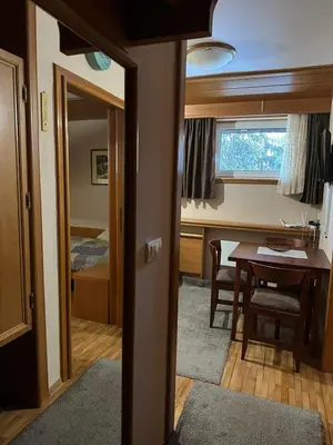 a room with a dining room table and a bedroom at Apartman 601 i 603 Kopaonik Centar in Kopaonik