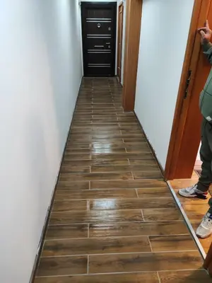 a hallway with a wooden floor and a door at Apartman 601 i 603 Kopaonik Centar in Kopaonik