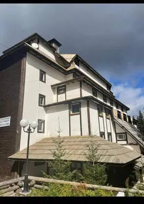 a large white building with a roof at Apartman 601 i 603 Kopaonik Centar in Kopaonik