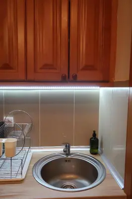 a sink in a kitchen with wooden cabinets at Apartman 601 i 603 Kopaonik Centar in Kopaonik