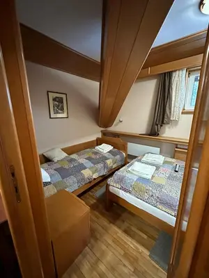 a small room with two beds and a mirror at Apartman 601 i 603 Kopaonik Centar in Kopaonik