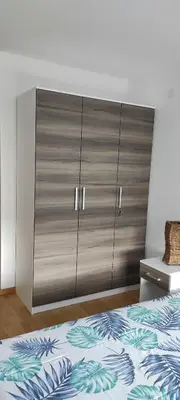 a large cabinet in a bedroom with a bed at LaNe apartman Sokobanja in Soko Banja