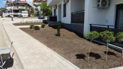 a garden in front of a building with trees at LaNe apartman Sokobanja in Soko Banja