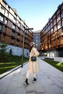 a woman in a coat walking down a sidewalk at Woodside TEA Residences & SPA Kopaonik in Kopaonik