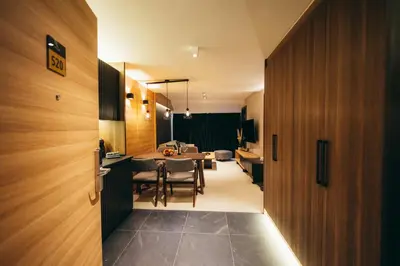 a kitchen and dining room with a table and chairs at Woodside TEA Residences & SPA Kopaonik in Kopaonik