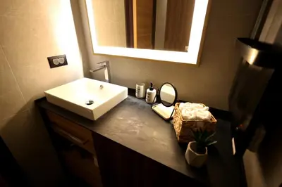 a bathroom with a sink and a mirror at Woodside TEA Residences & SPA Kopaonik in Kopaonik
