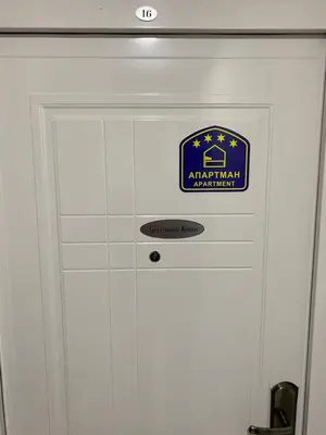 a white door with a blue sign on it at Apartman Kosta in Leskovac