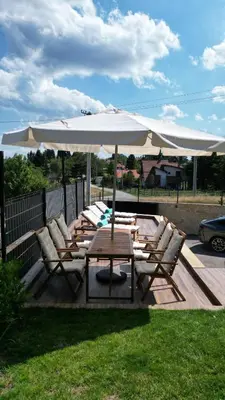 a table and chairs with an umbrella on a deck at V house Goc in Miodragoviči
