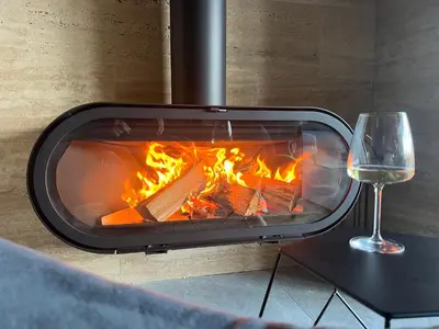 a fireplace with a glass of wine next to it at V house Goc in Miodragoviči