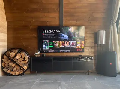 a television on a wooden wall with a sign at V house Goc in Miodragoviči
