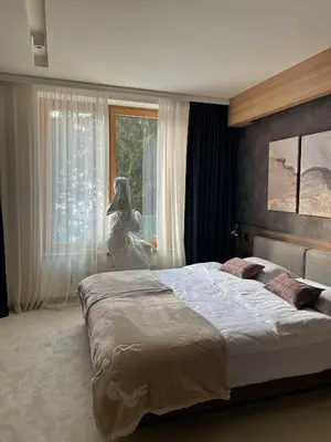 a bedroom with a large bed in front of a window at Apartman Kopaonik Woodside 106 in Kopaonik