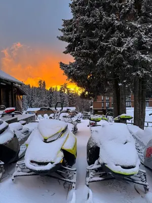 a group of benches covered in snow at sunset at Apartman Kopaonik Woodside 106 in Kopaonik