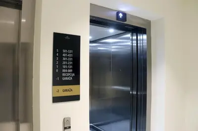 a stainless steel refrigerator with a sign on the wall at Superior Woodside Residences & Spa Kopaonik in Kopaonik