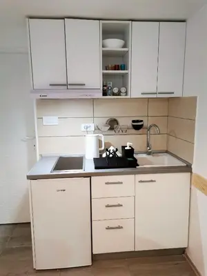 a kitchen with white cabinets and a sink at Kod Dede Brzece in Brzeće