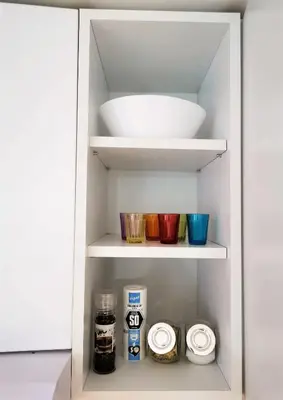 a white cabinet with bowls and other items in it at Kod Dede Brzece in Brzeće