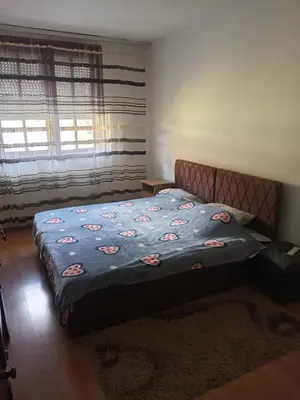 a bedroom with a bed with a blue blanket at Apartman Zivic in Berilovac