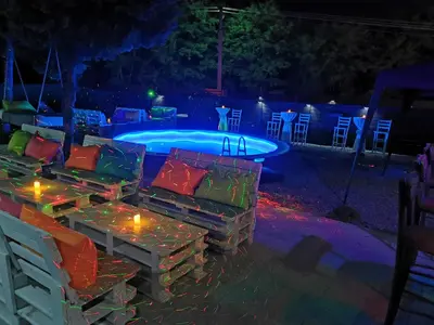a swimming pool at night with lights and torches at Odmaraliste Kod Miće Apartman 4 in Krušar