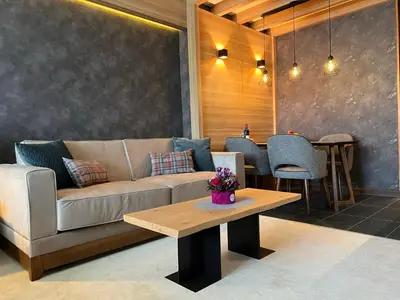 a living room with a couch and a table at Woodside Kopaonik 416 in Kopaonik