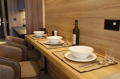 a table with bowls and a bottle of wine on it at Woodside Kopaonik in Kopaonik