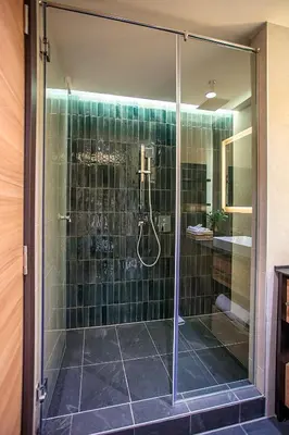 a bathroom with a shower with green tiles at Woodside Kopaonik in Kopaonik