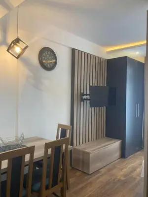 a dining room with a table and a clock on the wall at Kopaonik presidentKop apartman in Kopaonik