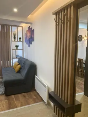 a living room with a blue couch in a room at Kopaonik presidentKop apartman in Kopaonik