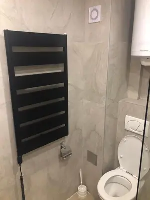 a bathroom with a toilet and a black shelf at Kopaonik presidentKop apartman in Kopaonik