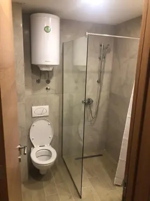 a bathroom with a toilet and a glass shower at Kopaonik presidentKop apartman in Kopaonik