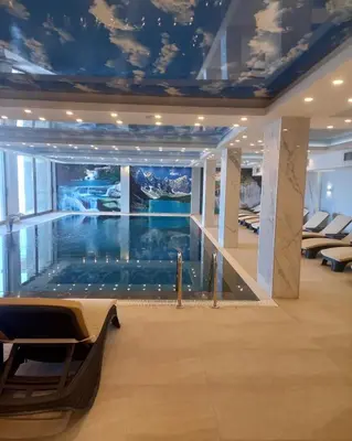 a large swimming pool in a building with a ceiling at Kopaonik presidentKop apartman in Kopaonik