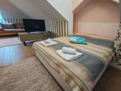a bedroom with a bed with towels on it at KONDOR apartmani in Vrnjačka Banja