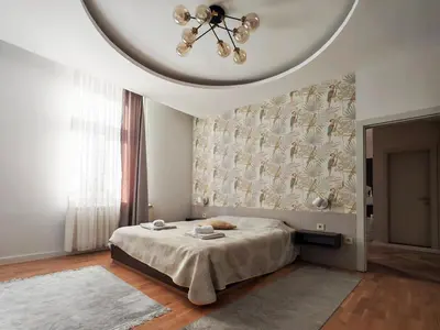 a bedroom with a large bed with a ceiling at KONDOR apartmani in Vrnjačka Banja
