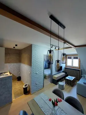 a living room with a couch and a table with chairs at VS Apartman , Hotel Župa Kopaonik in Kopaonik