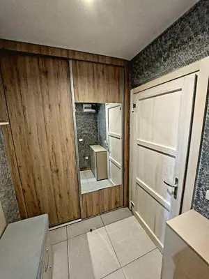 a kitchen with a wooden door and a refrigerator at VS Apartman , Hotel Župa Kopaonik in Kopaonik