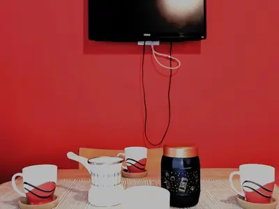 a table with cups and a tv on a red wall at Apartman Snezanka Kopaonik in Kopaonik