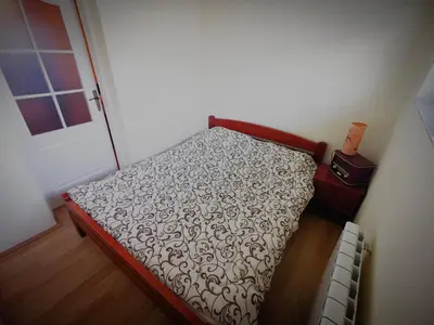 a small bed in a room with a door at Apartman Snezanka Kopaonik in Kopaonik