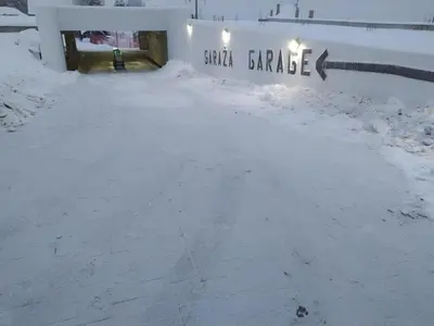 a snow covered road with a sign that reads small garage at NLux 10 Apartment in Kopaonik