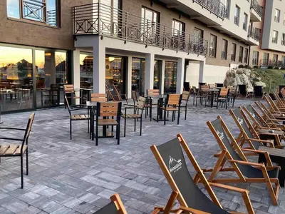 a row of chairs and tables and chairs on a patio at NLux 10 Apartment in Kopaonik
