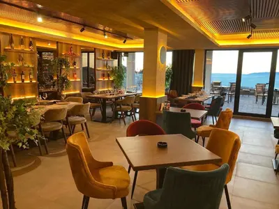 a restaurant with tables and chairs and windows at NLux 10 Apartment in Kopaonik