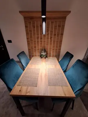 a wooden table with blue chairs around it at LUX Apartment STEVANOVIC A86 in Kopaonik